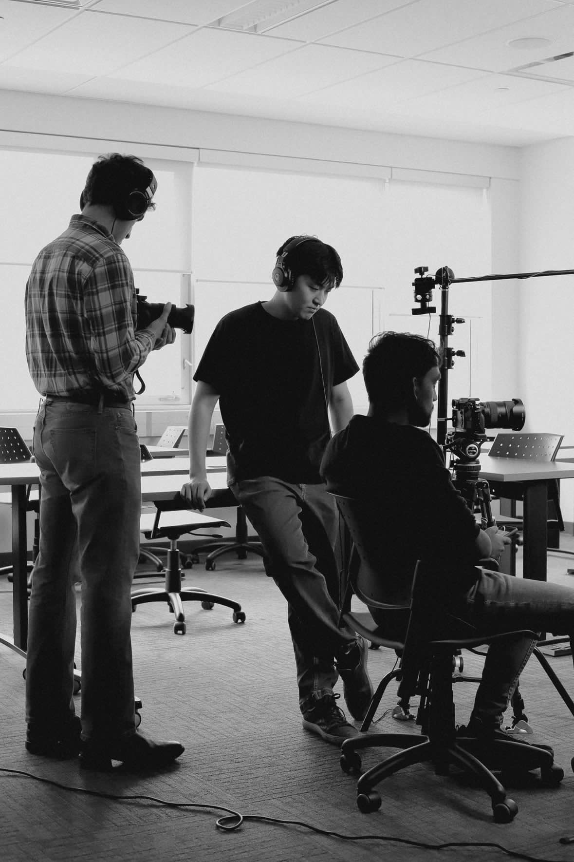 Boyi Tan monitoring a film setup with crew in a studio room